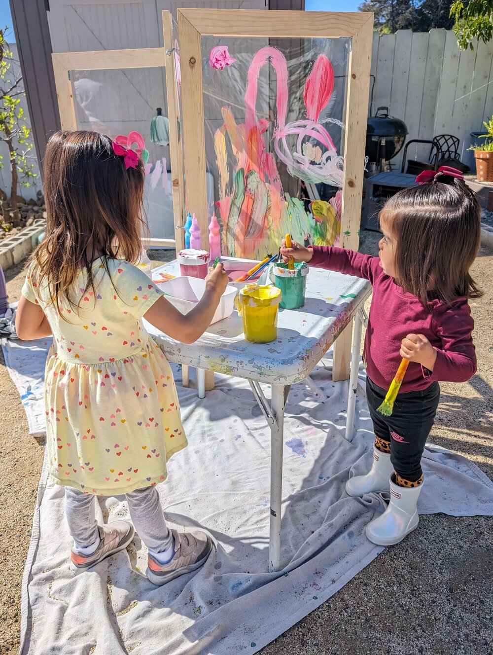 A toddler exploring paint at a sensory art station with a caregiver at Pachis art studio, Linda Vista